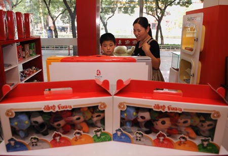 A mother and her child buy Olympic souvenirs in a shop in Taiyuan, capital of north China's Shanxi Province, Aug. 12, 2008. The Olympic souvenirs sell briskly in Taiyuan as the event goes on. [Xinhua] 