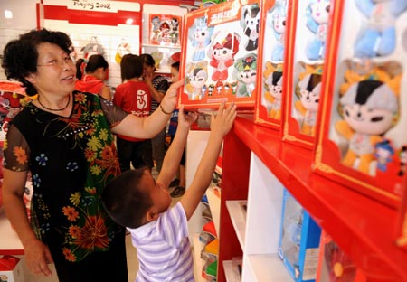  People buy 'Fuwa', mascots of the Beijing Olympic Games, at a shop in Taiyuan, capital of north China's Shanxi Province, Aug. 12, 2008. The Olympic souvenirs sell briskly in Taiyuan as the event goes on.[Xinhua]