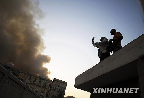 Two Egyptian reporters climb to a building to observe the fire that broke out in the building of the Egyptian Shura Council (Egypt's upper house of parliament) in downtown Cairo, injuring at least 13 people on Tuesday, August 19, 2008. [Photo: Xinhuanet]
