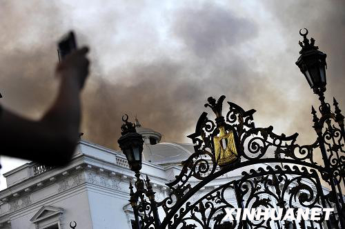 A local resident use his cell phone to take a picture of the fire that broke out in the Egyptian Shura Council building in downtown Cairo on Tuesday, August 19, 2008. [Photo: Xinhuanet]