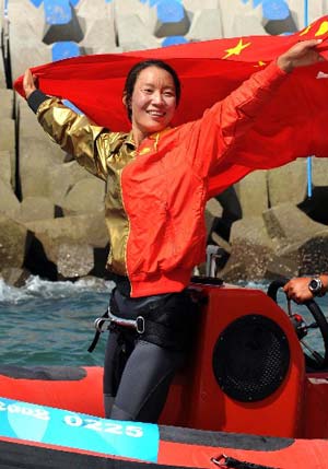 Chinese Yin Jian reacts after winning China's first ever Olympic sailing gold. Yin was crowned champion of RS:X Women at the Olympic Sailing Regatta here on Wednesday. [Song Zhenping/Xinhua]
