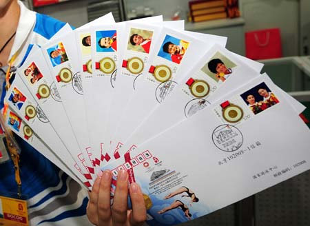 A volunteer shows the commemorative envelopes marking the gold medalists of China during the 29th Olympic Games, in Beijing, China, Aug. 19, 2008. These commemorative envelopes, each bearing a photo of the athlete who won gold medal for China during the Beijing Olympics, started to be sold to the public here on Tuesday. (Xinhua/Li Ziheng)
