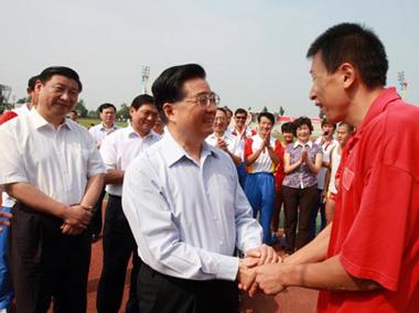 Chinese President Hu Jintao shakes hands with an athlete at the training center for Paralympic athletes in Beijing. [Xinhua]
