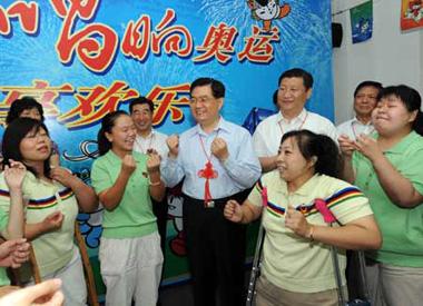 Chinese President Hu Jintao sings a song with some disabled people in Shichahai community home for the disabled in Beijing. [Xinhua]