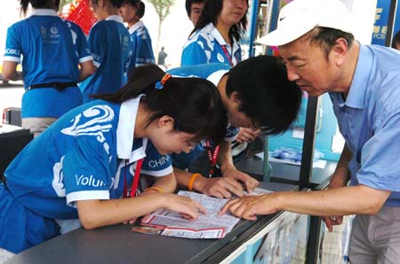 Volunteers check the map to guide the road for a visitor at a volunteer service station of the Beijing Exhibition Center in Beijing, capital of China, Aug. 20, 2008. Many volunteers appear at public places during the Beijing 2008 Olympic Games in Beijing and Olympics co-host cities to provide information, emergency aid and translation services etc. for people from around the world. (Xinhua/Zhao Yusi) 