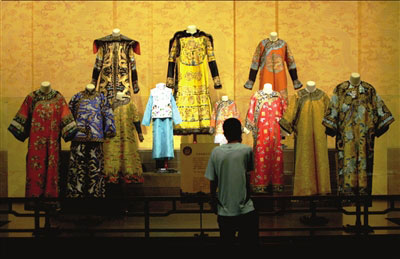 A tourist checks out court dresses from the Qing Dynasty on Tuesday, August 19, 2008. [Photo: Beijing Times]