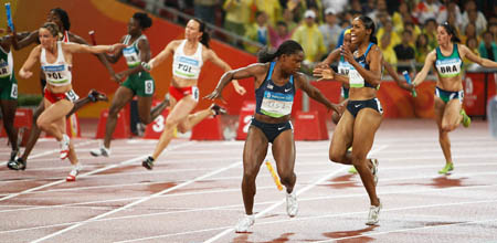 Torri Edwards (Front,R) reacts as her teammate Lauryn Williams (Front,L) lost the baton during the women's 4x100m realay first round at the National Stadium, also known as the Bird's Nest, during Beijing 2008 Olympic Games in Beijing, China, Aug. 21, 2008. [Xinhua/Liao Yujie]