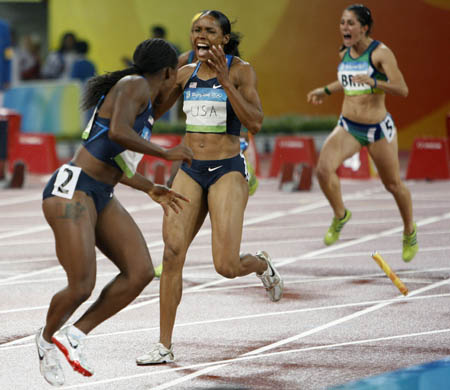Torri Edwards (L2) reacts as her teammate Lauryn Williams (L1) lost the baton during the women's 4x100m realay first round at the National Stadium, also known as the Bird's Nest, during Beijing 2008 Olympic Games in Beijing, China, Aug. 21, 2008. [Xinhua/Liao Yujie]