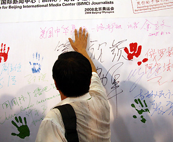 A reporter from China Business Herald leaves his signature and handprint on the canvas. [Wu Huanshu, Wang Yichen/China.org.cn] 