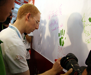 An overseas journalist signs the canvas to record his trip to China. [Wu Huanshu, Wang Yichen/China.org.cn] 