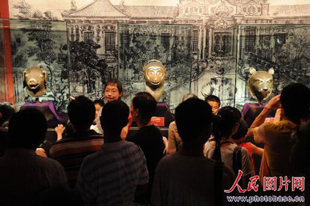 Visitors gaze at the pig, monkey, and tiger heads at the Hangzhou Poly Dongwan Exhibition Center on Wednesday, August 20, 2008. [Photo: photobase.cn]