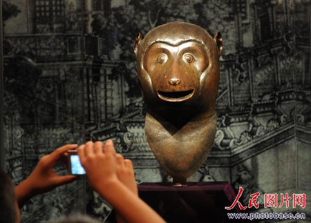 A visitor takes a photo of the monkey head at the Hangzhou Poly Dongwan Exhibition Center on Wednesday, August 20, 2008. [Photo: photobase.cn] 