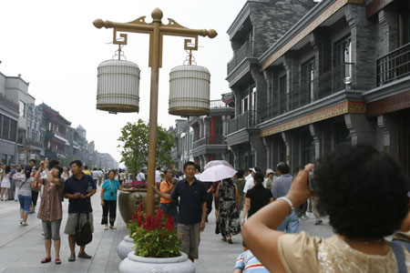 Tourists take pictures on the Qianmen Street in Beijing, capital of China, Aug. 20, 2008. Police began to restrict the flow of tourists in the Qianmen Street for their safety recently.[Lu Jinbo/Xinhua]