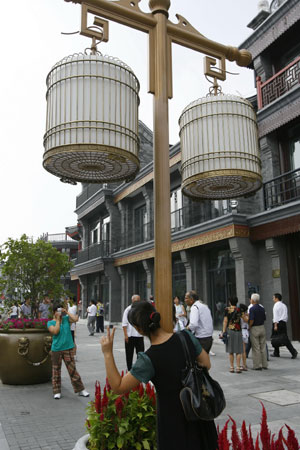 Tourists take pictures on the Qianmen Street in Beijing, capital of China, Aug. 20, 2008. [Lu Jinbo/Xinhua]