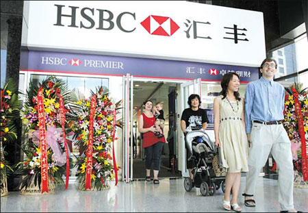 Customers walk out of the HSBC North Star sub-branch near the Bird's Nest in the file photo taken in Beijing. HSBC will open new branches in Zhengzhou and Ningbo in a move that underpins the bank's confidence in China's long-term growth prospects amid global market concerns, HSBC China President and CEO Richard Yorke said. [File photo: China Daily]