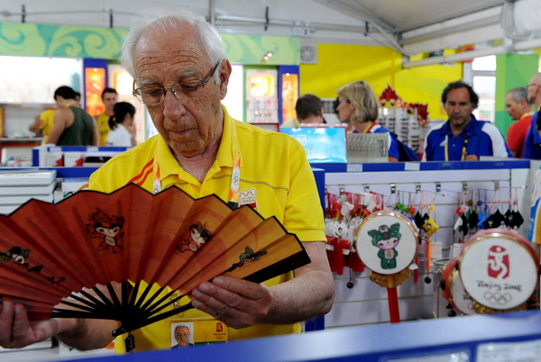 A tourist from Spain buys Olympic souvenirs in the commercial and cultural street of the Beijing Olympic Village on August 20, 2008.