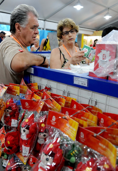 Foreign tourists buy Olympic souvenirs in the commercial and cultural street of the Beijing Olympic Village on August 20, 2008.