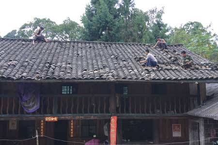 Villagers repair the roof of a house damaged by the tremor at Pishi Village in Yingjiang County of Dehong Dai and Jingpo Autonomous Prefecture, southwest China's Yunnan Province, Aug. 20, 2008. (Xinhua Photo)