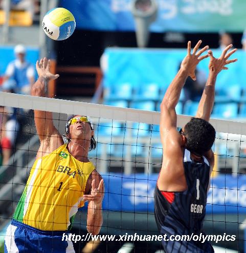 Ricardo Santos (L) of Brazil spikes the ball over Renato Gomes of Georgia during their beach volleyball bronze medal match at the Beijing Olympic Games in Beijing, China, Aug. 22, 2008. Ricardo Santos/Emanuel Rego of Brazil won the match and grabbed the bronze medal of the event. [Sadat/Xinhua]