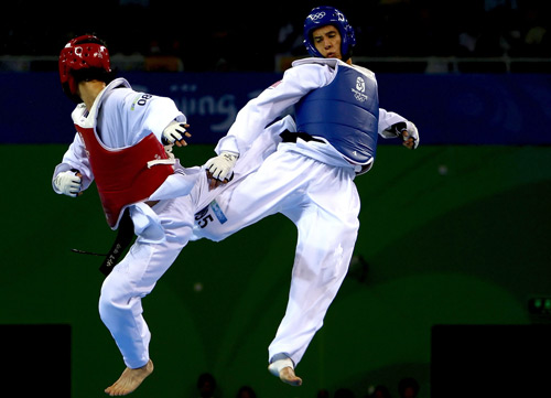 Son Tae-jin (red) competes against Mark Lopez (blue). [BOCOG]