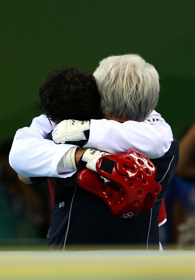 Son Tae-jin hugs his coach after his win.[BOCOG]