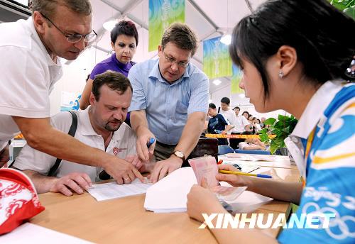 Russian visitors fill out forms before entering the Olympic Village on Friday, August 22, 2008. [Photo: Xinhuanet]