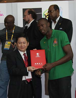 Liu Xuanguo (L front), vice general secretary of the Chinese Red Cross Foundation (CRCF), presents the certificate of donation to Jamaican athlete Usain Bolt (R front) during a donation ceremony in Beijing, capital of China, Aug. 23, 2008. Usain Bolt, who won three gold medals in the men's 100m, men's 200m, and men's 4x100m relay competitions of the Beijing 2008 Olympic Games, donates US$50,000 through the CRCF to the children in the earthquake-hit areas of China on Saturday, and invites six earthquake-affected children to travel to Jamaica. [Xinhua] 