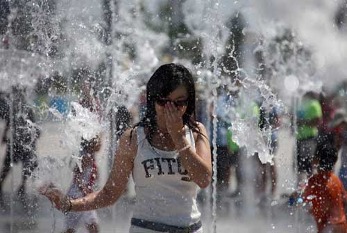 A girl plays in a water fountain outside the Bird's Nest, August 23, 2008. Sixteen days after the awe-inspiring Opening Ceremony, Beijing awaits the scheduled closing ceremony of the Olympic Games in the Bird's Nest Sunday night August 24. [Xinhua]