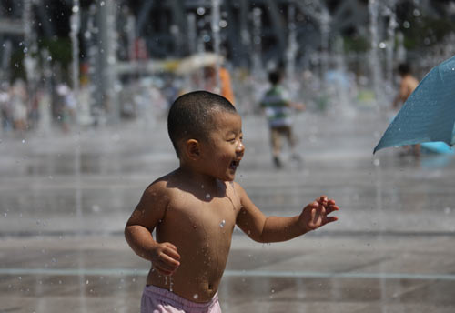 A boy plays in a water fountain outside the Bird's Nest, August 23, 2008. Sixteen days after the awe-inspiring Opening Ceremony, Beijing awaits the scheduled closing ceremony of the Olympic Games in the Bird's Nest Sunday night August 24. [Xinhua]