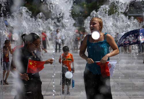 Visitors play in a water fountain outside the Bird's Nest, August 23, 2008. Sixteen days after the awe-inspiring Opening Ceremony, Beijing awaits the scheduled closing ceremony of the Olympic Games in the Bird's Nest Sunday night August 24. [Xinhua]