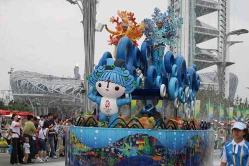 Performers dance on a float decorated with Fuwa Beibei, one of the Beijing Olympic mascots, during a parade along the Olympic Green in Beijing, August 22 2008.