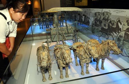 A visitor looks at the replica of a bronze chariot from the Qin Dynasty (BC 221-206) at the Ningxia Transportation Museum in Yinchuan, capital of northwest China's Ningxia Hui Autonomous Region, August 22, 2008. The museum was opened to public on Friday. 