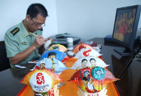 Border police officer Huang Baobang paints on a crab shell in Zhoushan, east China&apos;s Zhejiang Province, Aug. 23, 2008. Huang draws the pictures of Olympic winning athletes, logos of the Beijing Olympics, and Chinese characteristic patterns on more than 100 crab shells during the Beijing 2008 Olympic Games. 