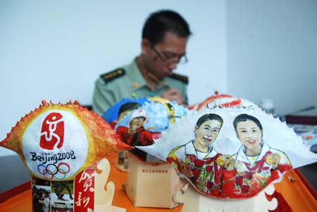 Border police officer Huang Baobang paints on a crab shell in Zhoushan, east China&apos;s Zhejiang Province, Aug. 23, 2008. Huang draws the pictures of Olympic winning athletes, logos of the Beijing Olympics, and Chinese characteristic patterns on more than 100 crab shells during the Beijing 2008 Olympic Games. 