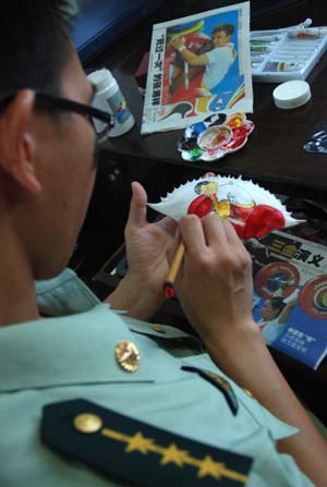 Border police officer Huang Baobang paints on a crab shell in Zhoushan, east China&apos;s Zhejiang Province, Aug. 23, 2008. Huang draws the pictures of Olympic winning athletes, logos of the Beijing Olympics, and Chinese characteristic patterns on more than 100 crab shells during the Beijing 2008 Olympic Games. 