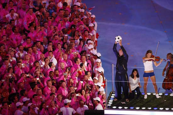 British soccer superstar David Beckham (C) throws a “welcome ball” from atop a red double-decker bus during the eight-minute performance prepared by London, host city of the next summer Olympic Games in 2012, at the Beijing 2008 Olympic Games closing ceremony held in the National Stadium, or the Bird's Nest, Beijing, capital of China, Aug. 24, 2008. (Xinhua/Liao Yujie) 