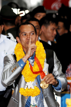 Somjit Jongjohor of Thailand, who won the gold medal of the Men's Fly (51kg) of the 2008 Beijing Olympic Games boxing event, gestures to people upon his arrival at the Bangkok International Airport in Bangkok, capital of Thailand, Aug. 25, 2008.
