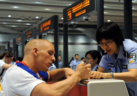 A foreign passenger checks in at a counter at the Beijing Capital International Airport in Beijing, capital of China, Aug. 25, 2008. The airport saw a peak traffic volume on Monday as many Olympic delegations left the Chinese capital. A total of 32,596 passengers would leave Beijing throughout the day, doubling the usual figure. (Xinhua/Tang Zhaoming)
