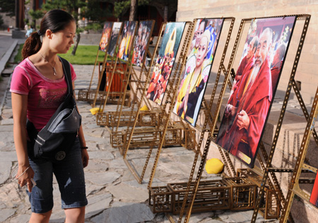 A tourist views a photo exhibition on the Wutai Mountain in north China&apos;s Shanxi Province, Aug. 24, 2008. The Wutai Mountain opened its 5th Buddhism Cultural Festival recently to showcase its cultural tradition and natural charm, as a new effort in its application to be listed among the world&apos;s natural and cultural heritages. 