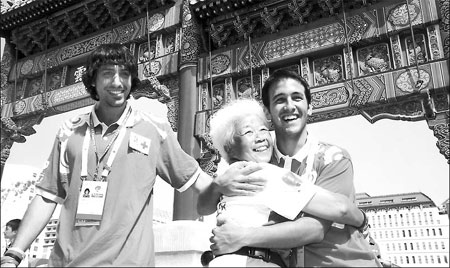  Hasta la vista, baby: Two Olympic volunteers from Spain say farewell to a Chinese friend yesterday at the Xidan Cultural Square before heading home. [Xinhua]