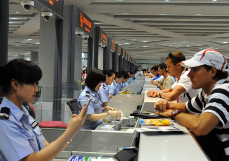 Passengers check in in front of counters at the Beijing Capital International Airport in Beijing, capital of China, Aug. 25, 2008. The airport saw a peak traffic volume on Monday as many Olympic delegations left the Chinese capital. A total of 32,596 passengers would leave Beijing throughout the day, doubling the usual figure. (Xinhua/Tang Zhaoming)