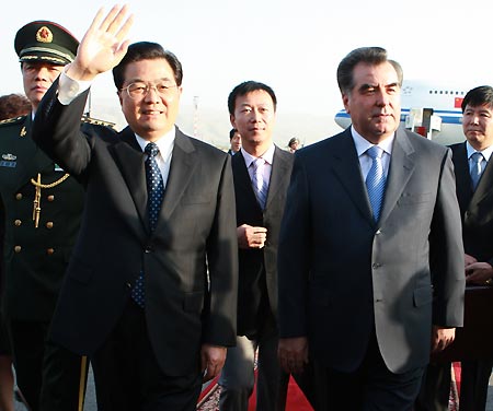 Chinese President Hu Jintao (L Front) waves to people as Tajik President Emomali Rakhmon (R Front) greets him at the airport in Tajikistan's capital Dushanbe Aug. 26, 2008. [Ju Peng/Xinhua]