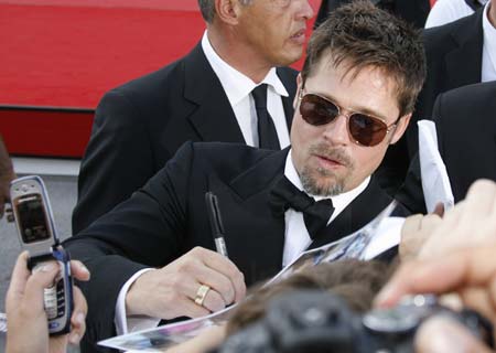 U.S. actor Brad Pitt signs autograph before a screening in Venice August 27, 2008. 