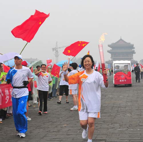 Photo: Torchbearer Zhang Xiulin runs with the torch