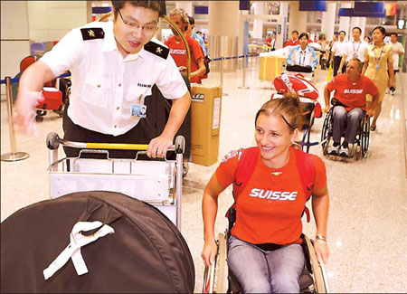 A customs officer helps a member of the Swiss Paralympic delegation with her luggage August 28, 2008, at the Capital International Airport in Beijing. [China Daily]