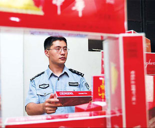 A policeman checks some of the cigarettes smuggled through Fujian and Guangdong provinces between 2003 and 2006. File Photo