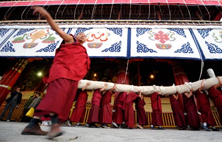Tibetan lamas carry a large tangka, a kind of scroll painting mounted on brocade with the image of Buddhist to be displayed at the opening ceremony of the Shoton (Yogurt) Festival celebration in Zhaibung Monastery in Lhasa, capital of Tibet Autonomous Regional, August 30, 2008. Tangka Paintings display is one of the various activities held during the Shoton Festival.