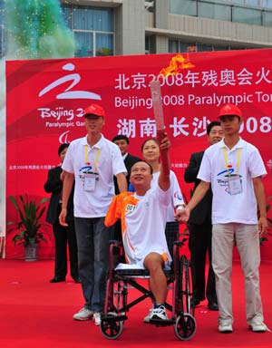 Torchbearer Zhu Weiming demonstrates the torch during the Beijing 2008 Paralympic torch relay in Changsha, capital of central China's Hunan Province, China, Aug. 31, 2008.