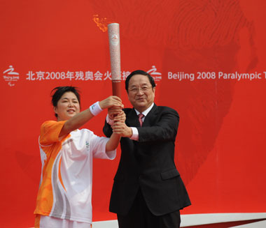 Yu Zhengsheng (R), the city's Party Secretary, holds the 2008 Beijing Paralympic Games torch with the first torch bearer Zhao Jihong, the first Chinese athlete to break a world record in the Paralympic Games.  