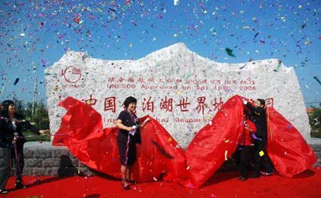 People unveil the monument for the Mudanjiang Global Geopark in Mudanjiang, northeast China's Heilongjiang Province, Aug. 30, 2008. The Mudanjiang Global Geopark, elected as a global geopark at the 2nd International Geography Press in September 2006, opened on Saturday.